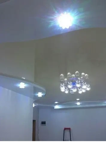 Фигурный натяжной потолок в белом и бежевом исполнении.