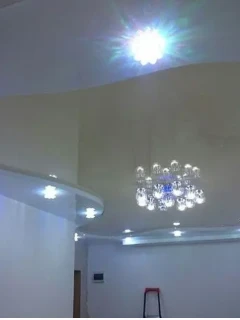 Фигурный натяжной потолок в белом и бежевом исполнении.